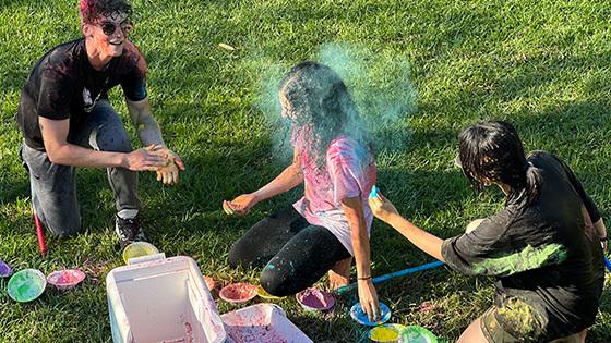 学生 throw colored powder at the Holi Festival of Colors.