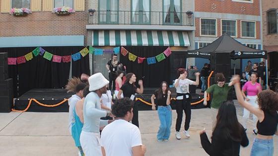 A group dancing at the Latin 音乐 Festival hosted at the 满帆 Backlot.